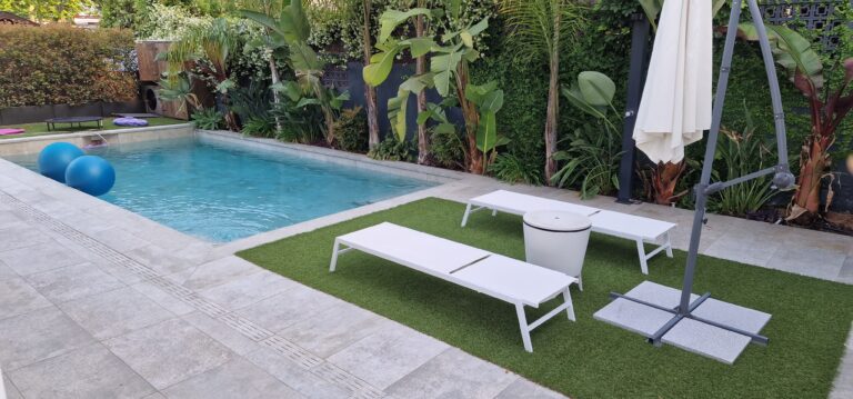 piscina con tumbonas en un jardín de chalet